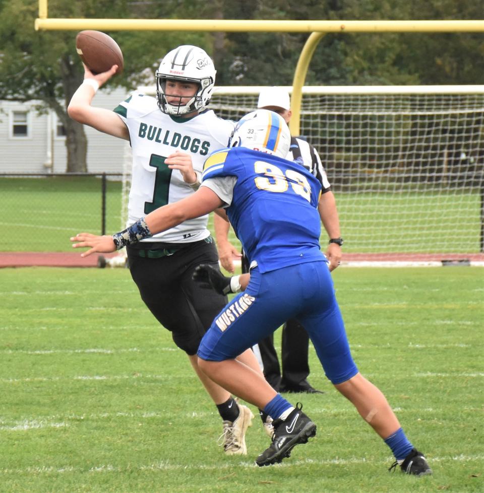 Westmoreland/Oriskany quarterback Dylan Williams (1) throws the ball under presure from Mt. Markham Mustang Evan Kocienda during the first half of Saturday's game.