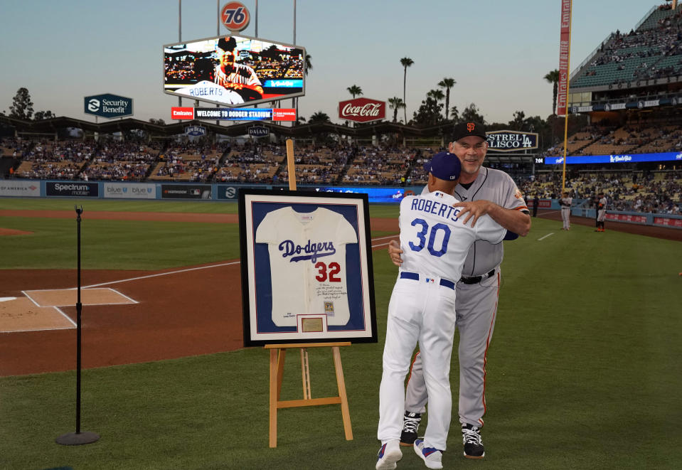 Sep 6, 2019; Los Angeles, CA, USA; Los Angeles Dodgers manager Dave Roberts (30) presents retiring San Francisco Giants manager Bruce Bochy (15) an autographed Sandy Koufax jersey before a game at Dodger Stadium. Mandatory Credit: Kirby Lee-USA TODAY Sports