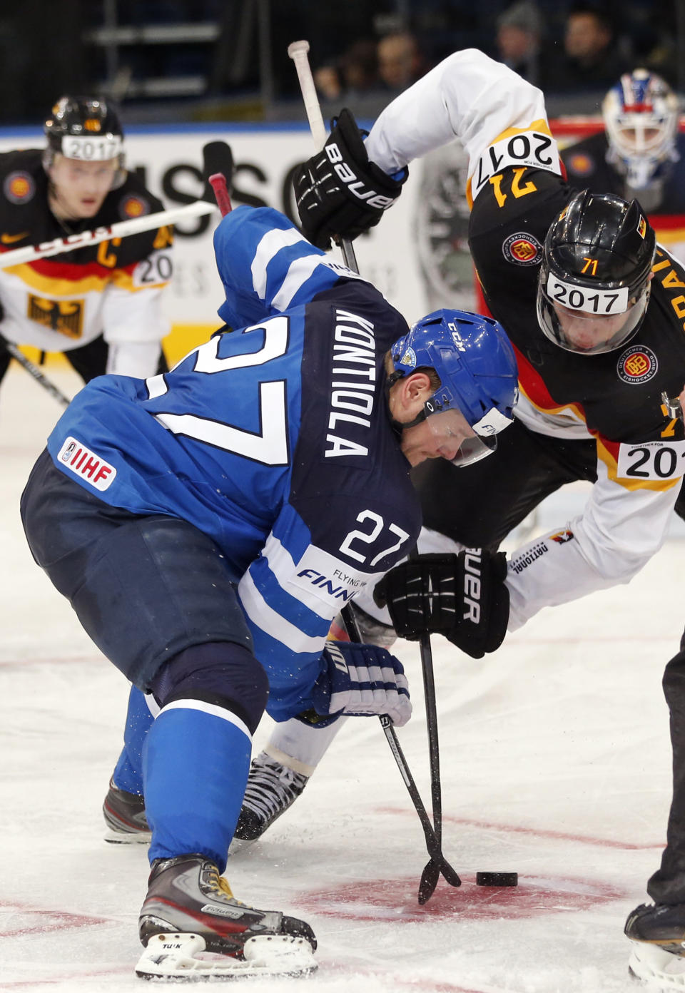 Finland forward Petri Kontiola, left, battles for the puck with Germany forward Leon Draisaitl during the Group B preliminary round match between Germany and Finland at the Ice Hockey World Championship in Minsk, Belarus, Tuesday, May 13, 2014. (AP Photo/Darko Bandic)