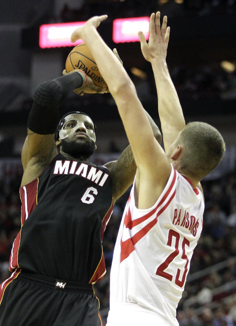 Miami Heat forward LeBron James (6) takes a shot over Houston Rockets forward Chandler Parsons (25) during the second quarter of an NBA basketball game, Tuesday, March. 4, 2014, in Houston. (AP Photo/Patric Schneider)