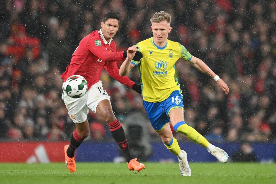 MANCHESTER, ENGLAND - FEBRUARY 01: Raphael Varane of Manchester United battles for possession with Sam Surridge of Nottingham Forest during the Carabao Cup Semi Final 2nd Leg match between Manchester United and Nottingham Forest at Old Trafford on February 01, 2023 in Manchester, England.