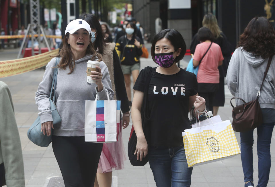 People wear face masks to protect against the spread of the coronavirus as they walk through a shopping district in Taipei, Taiwan, Thursday, Oct. 29, 2020. (AP Photo/Chiang Ying-ying)