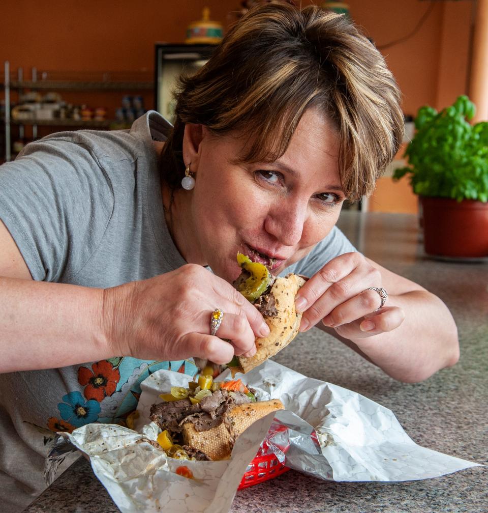 Valda Palterman at Culinary Delights in Natick enjoys a Chicago style Italian beef sandwich: roll dipped in au jus, 1/3 pound of homemade Italian seasoned Angus roast beef, sauteed sweet peppers, and hot giardiniera, Aug. 4, 2023.