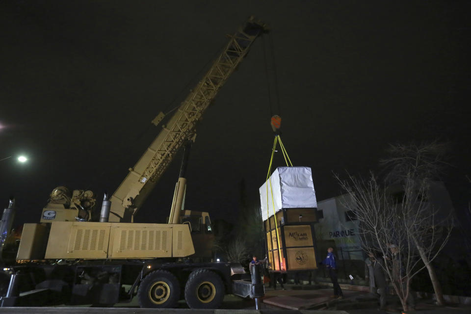 Workers load a case carrying Benito the giraffe into a truck at the city-run Central Park zoo in Ciudad Juarez, Mexico, Sunday, Jan. 21, 2024. After a campaign by environmentalists, Benito left Mexico's northern border and its extreme weather conditions Sunday night and headed for a conservation park in central Mexico, where the climate is more akin to his natural habitat and already a home to other giraffes. (AP Photo/Christian Chavez)