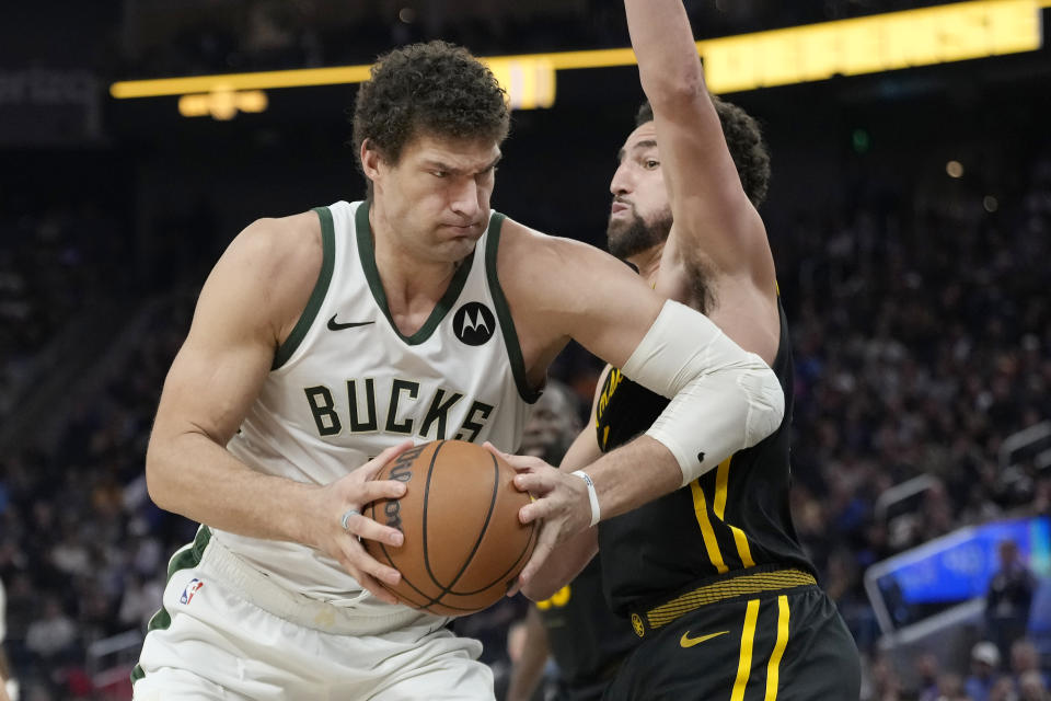 Milwaukee Bucks center Brook Lopez, left, drives to the basket against Golden State Warriors guard Klay Thompson during the first half of an NBA basketball game in San Francisco, Wednesday, March 6, 2024. (AP Photo/Jeff Chiu)