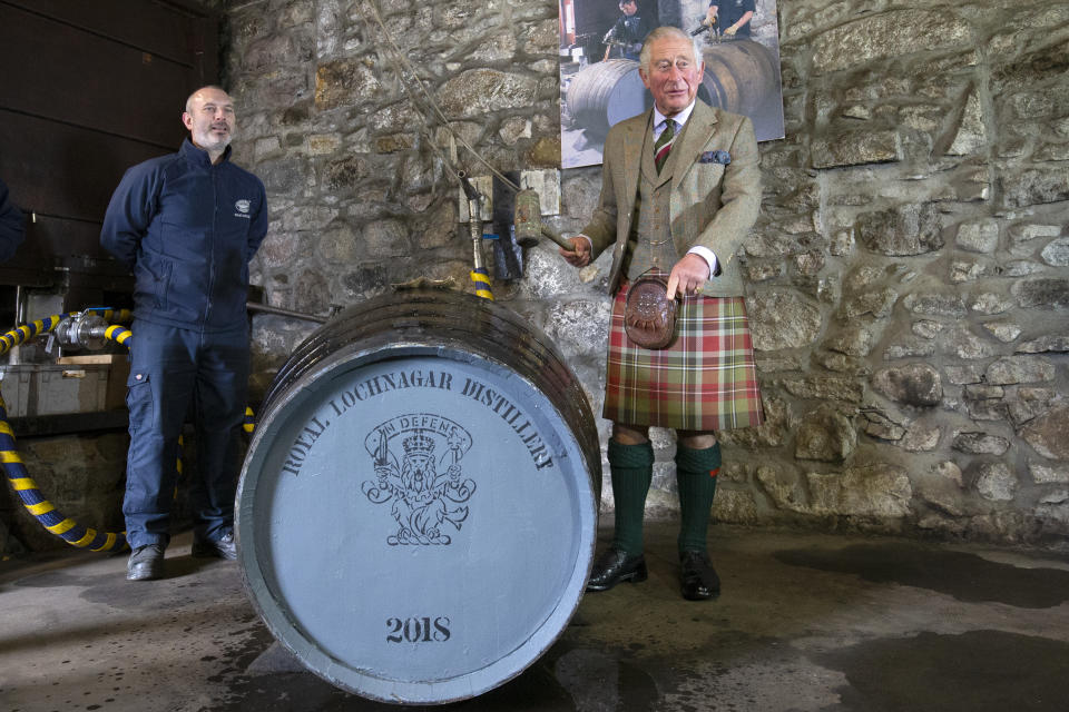 Prince Charles fills a new whisky cask, alongside senior operator Ryan Cromar at the Royal Lochnagar Distillery (PA)