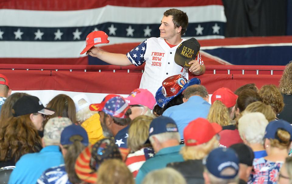 A Donald Trump supporter displays caps in the front row of Erie Insurance Arena prior to the Trump rally in Erie on July 29, 2023.