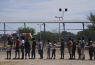 Migrants, many from Haiti, line up to receive food at an improvised refugee camp at a sport park in Ciudad Acuña, Mexico, Wednesday, Sept. 22, 2021, (AP Photo/Fernando Llano)