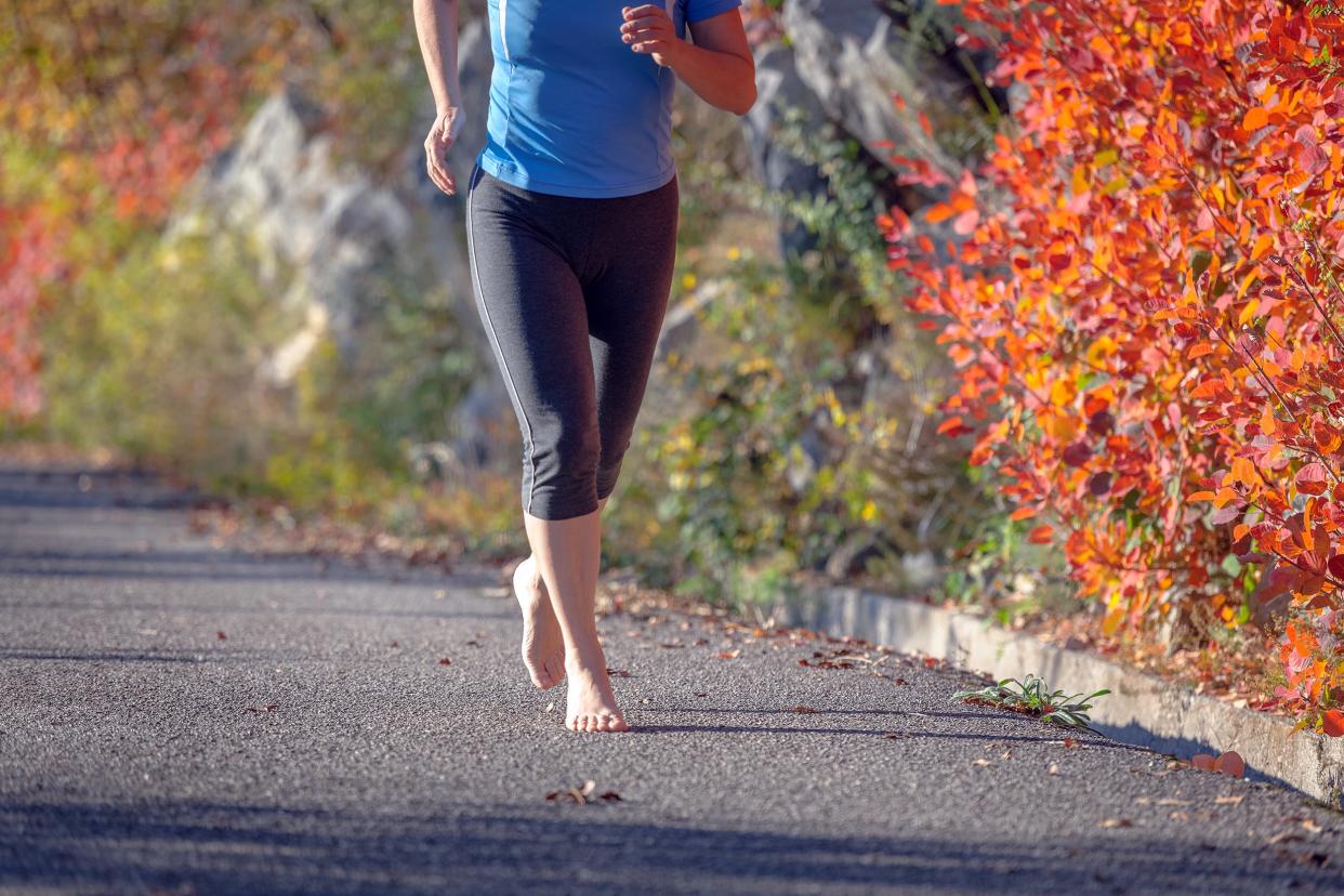 woman outdoors running barefoot