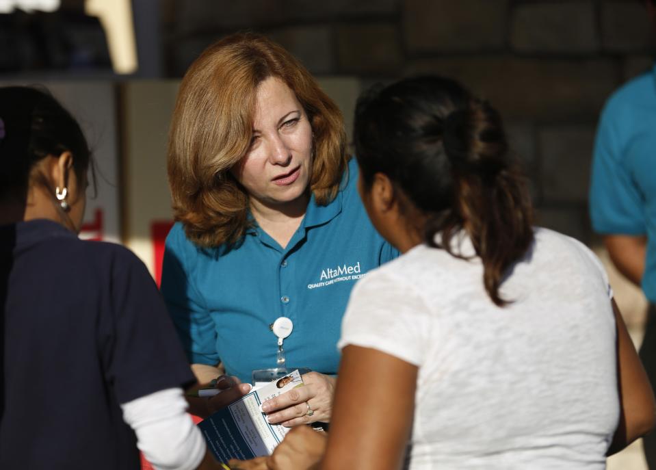 Engrith Acosta, patient care coordinator at AltaMed, speaks to people during a community outreach on Obamacare in Los Angeles, California November 6, 2013. Concerns among Hispanics that signing up for medical insurance under President Barack Obama's healthcare law may draw the scrutiny of immigration authorities has hurt enrollment, according to advocates of the policy. To match Feature USA-HEALTHCARE/HISPANICS Picture taken November 6, 2013. REUTERS/Mario Anzuoni (UNITED STATES - Tags: HEALTH POLITICS)