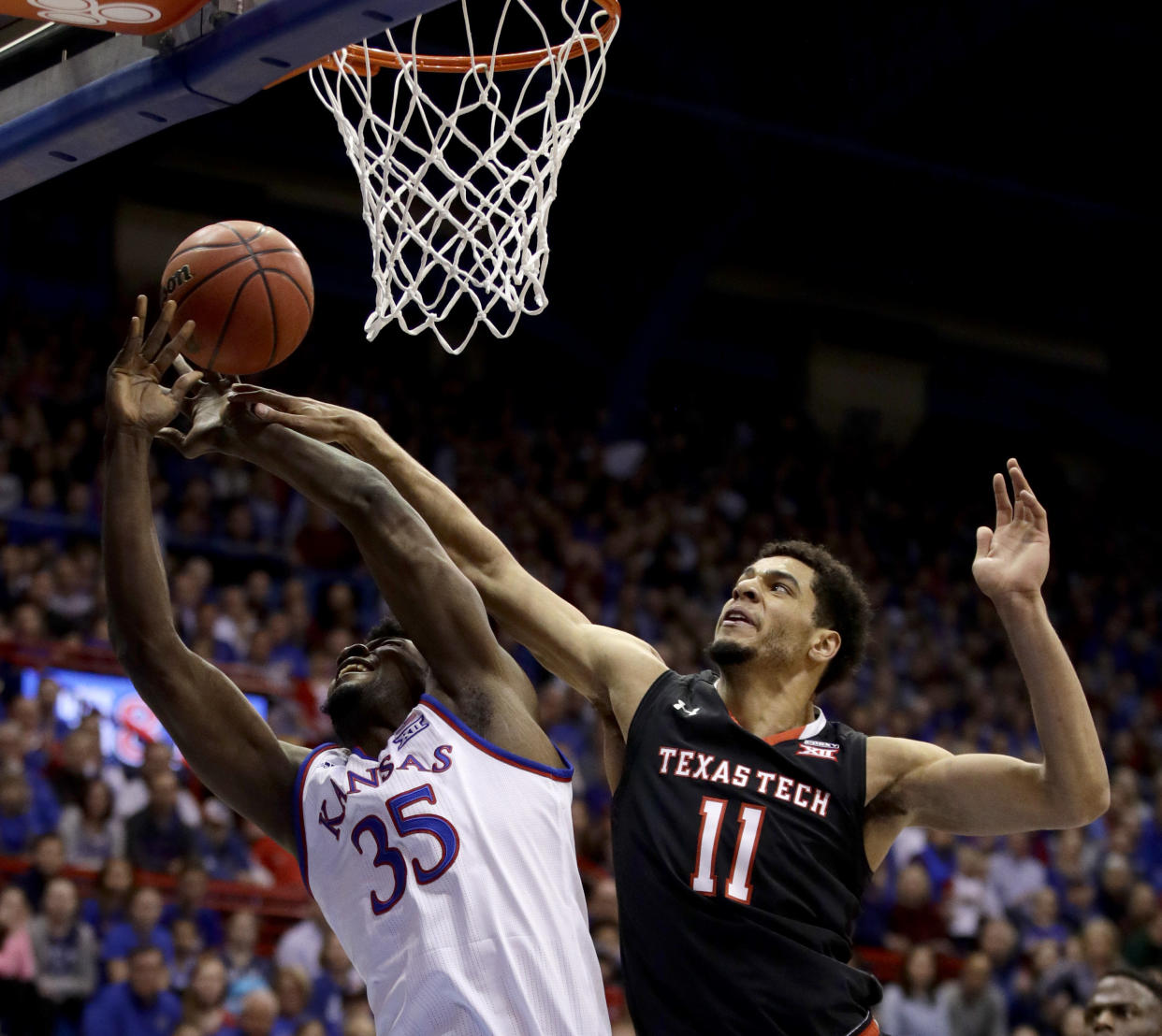 Kansas’ Udoka Azubuike (35) is fouled by Texas Tech’s Zach Smith (11) as he shoots during the first half of an NCAA college basketball game Tuesday, Jan. 2, 2018, in Lawrence, Kan. (AP Photo/Charlie Riedel)
