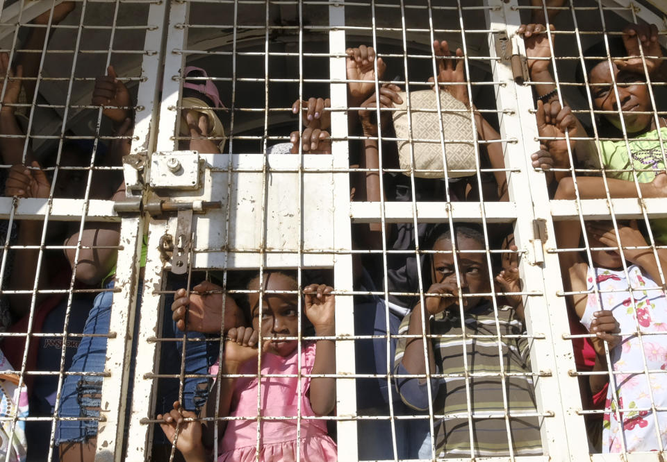 ARCHIVO - Haitianos detenidos para ser deportados observan desde un vehículo policial en un puente fronterizo entre Dajabón, República Dominicana, y Haití, el miércoles 11 de octubre de 2023. (AP Foto/Ricardo Hernández, Archivo)