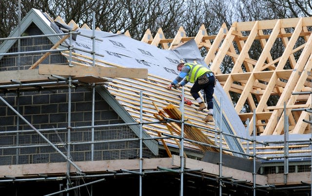 Builder on roof of partially built house