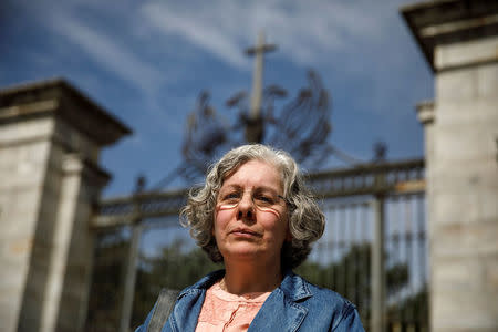 Maria Purificacion Lapena, granddaughter of civil war victim Manuel Lapena, poses outside the entrance to the Basilica of the Valley of the Fallen (Valle de los Caidos), the giant mausoleum holding the remains of dictator Francisco Franco and over 30,000 civil war dead from both sides, where a scientific team entered to search for the remains of four of the dead for the first time after a court order approved the exhumation of two victims, Manuel and Antonio Lapena, executed in 1936 by Franco's forces during the Spanish Civil War, in San Lorenzo de El Escorial, Spain, April 23, 2018. REUTERS/Juan Medina