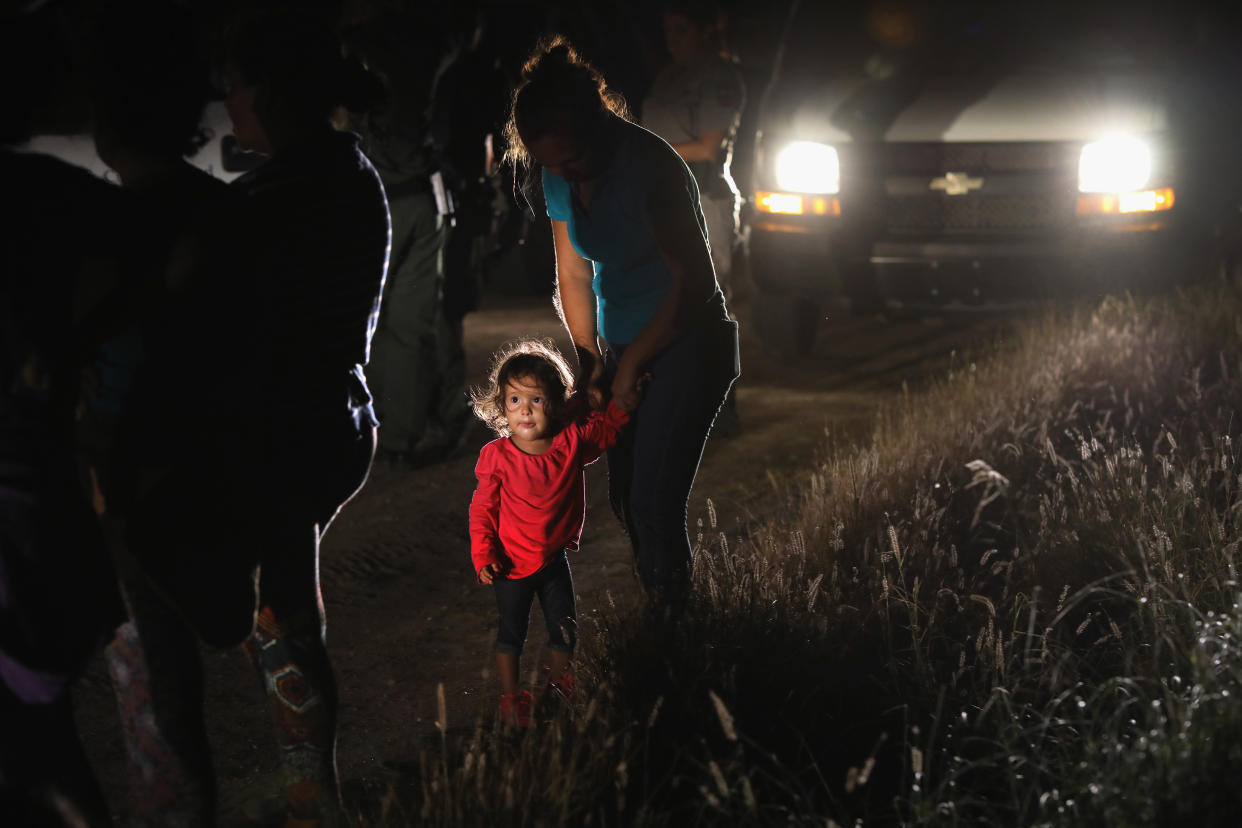 A 2-year-old Honduran stands with her mother after being detained by U.S. Border Patrol agents near the U.S.-Mexico border on June 12. (Photo: John Moore via Getty Images)