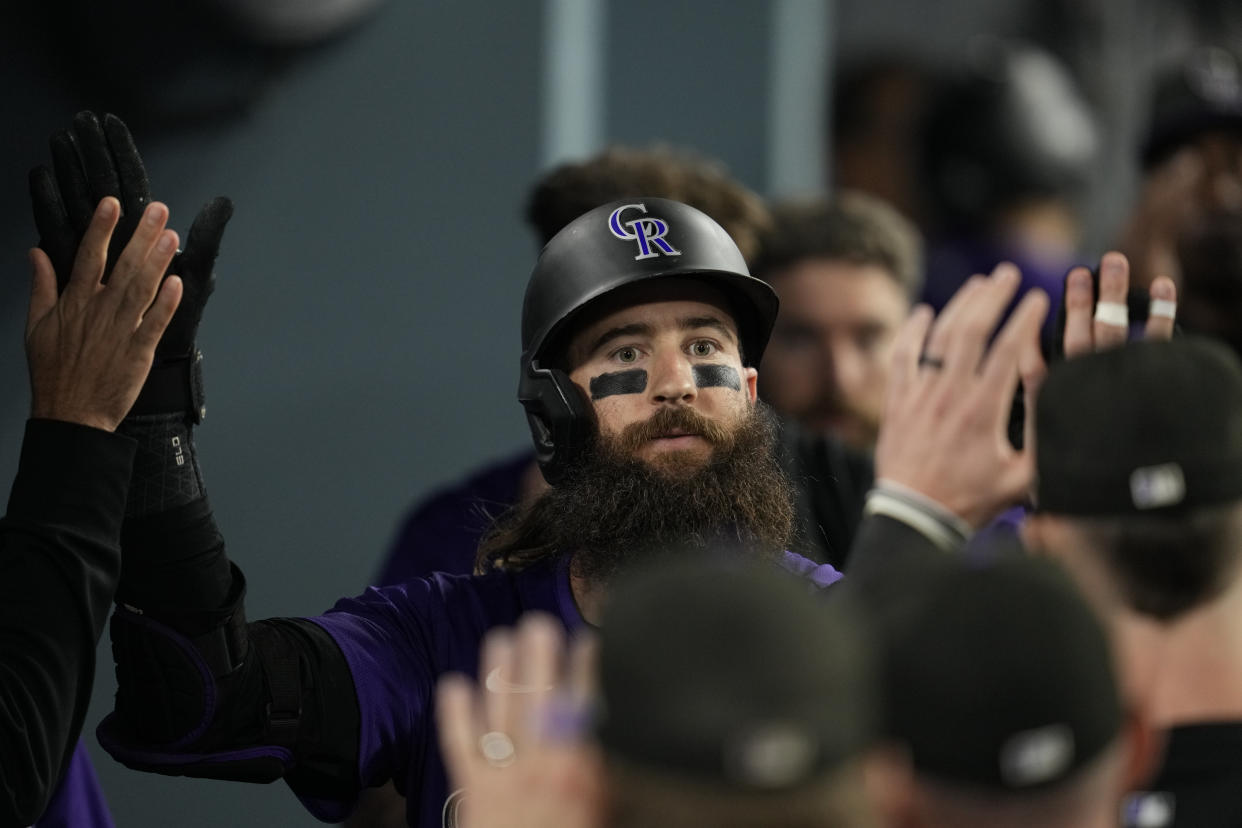 Colorado Rockies' Charlie Blackmon celebrates in the dugout after hitting a home run during the fifth inning of a baseball game against the Los Angeles Dodgers in Los Angeles, Friday, Sept. 20, 2024. (AP Photo/Ashley Landis)