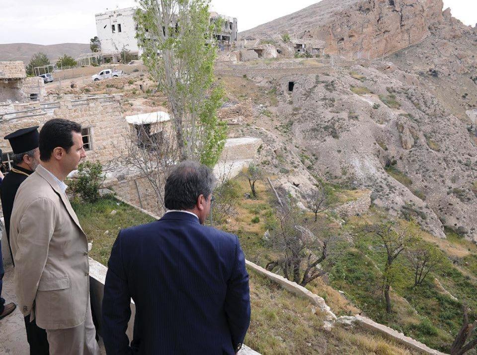 In this photo released by the Syrian official news agency SANA, Syrian President Bashar Assad, center, tours the Christian village of Maaloula, near Damascus, Syria, Sunday April, 20, 2014. Assad visited a historic Christian village his forces recently captured from rebels, state media said, as the country's Greek Orthodox Patriarch vowed that Christians in the war-ravaged country "will not submit and yield" to extremists. The rebels, including fighters from the al-Qaida-affiliated Nusra Front, took Maaloula several times late last year. (AP Photo/SANA)