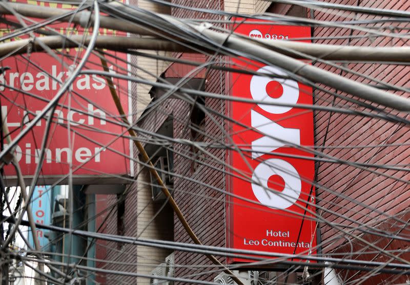 FILE PHOTO: The logo of OYO installed on a hotel building is seen through wires in an alley in New Delhi