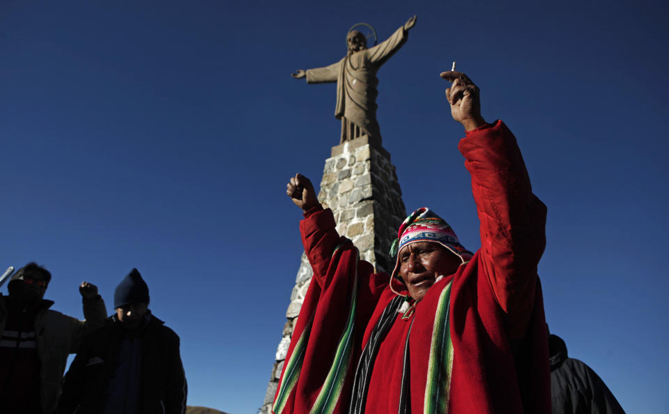 An Aymara priest leads a prayer after an offering ceremony to "Pachamama," or "Mother Earth," on La Cumbre, a mountain that is considered scared ground, on the outskirts of La Paz, Bolivia, Friday, Aug. 1, 2014. The month of August is the time people gather in the mountains of Bolivia to make offerings in honor of the earth goddess and ask for good fortune. According to local agrarian tradition, Mother Earth awakes hungry and thirsty in August and needs offerings of food and drink in order for to be fertile and yield abundant crops. (AP Photo/Juan Karita)