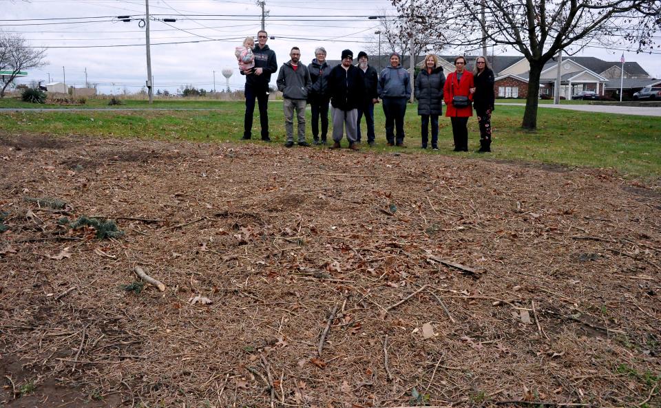 Members of the Frontz family stand where the tree grew. (Left to right) Kailyn Frontz, Brian Frontz, Ethan Frontz, Veronica Frontz, Kevin Frontz, Rod Frontz, Steve Frontz, Chris Frontz, Barb Geiser and Ericka Burgin.