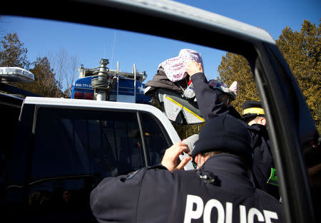 A child in a carseat is lifted by Royal Canadian Mounted Police (RCMP) officers as a family of four are taken into custody after crossing the U.S.-Canada border into Hemmingford, Quebec, Canada February 20, 2017. REUTERS/Christinne Muschi