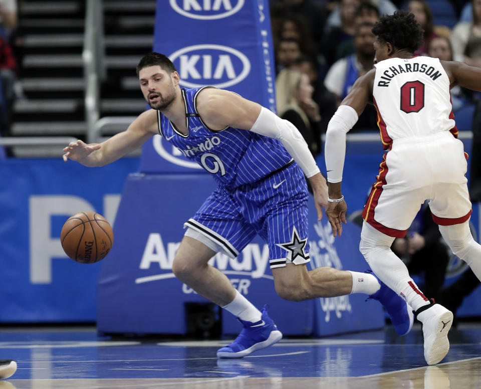 Orlando Magic's Nikola Vucevic, left, goes after a loose ball in front of Miami Heat's Josh Richardson (0) during the first half of an NBA basketball game, Sunday, Dec. 23, 2018, in Orlando, Fla. (AP Photo/John Raoux)