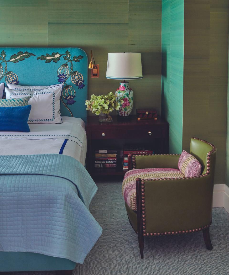 Green wallpaper, blue bedframe, armchair