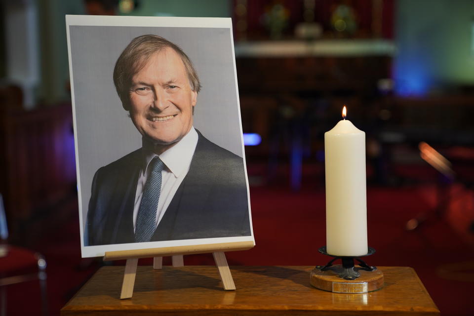 A candle and a photo at a vigil at St Michael & All Angels church in Leigh-on-Sea Essex for Conservative MP Sir David Amess, who died after he was stabbed several times at a constituency surgery on Friday. (PA)