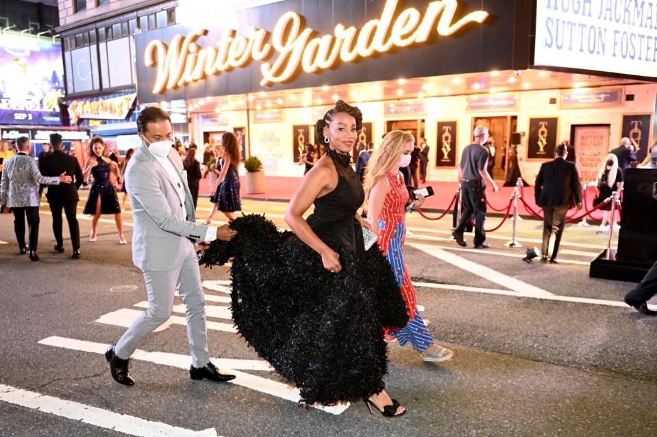 Anika Noni Rose arrives, the train of her long dress carried for her.