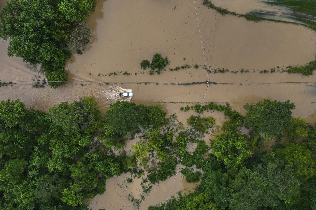 A truck drives along flooded Wolverine Road in Breathitt County, Ky. on Thursday, July 28, 2022. Heavy rains have caused flash flooding and mudslides as storms pound parts of central Appalachia. Kentucky Gov. Andy Beshear says it's some of the worst flooding in state history.