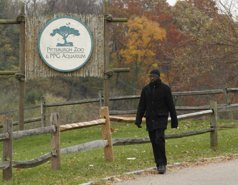 A man walks by a sign near the entrance to the parking lots for the Pittsburgh Zoo and PPG Aquarium on Monday, Nov. 5, 2012, in Pittsburgh. Zoo officials said a young boy was killed after he fell into the exhibit that was home to a pack of African painted dogs, who pounced on the boy and mauled him on Sunday, Nov. 4, 2012. It's not yet clear whether the boy died from the fall or the attack, said Barbara Baker, president of the Pittsburgh Zoo & PPG Aquarium. (AP Photo/Keith Srakocic)