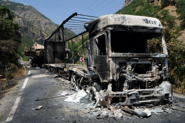 A picture shows two burnt trucks reportedly set on fire by Kurdistan Workers' Party (PKK) militants in Tunceli, eastern Turkey, on August 2, 2015