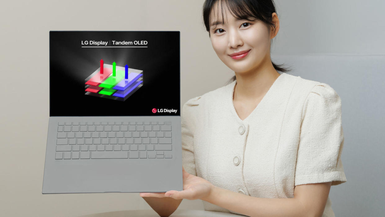  A promotional photo of a person holding a laptop sporting a tandem OLED display panel by LG. 