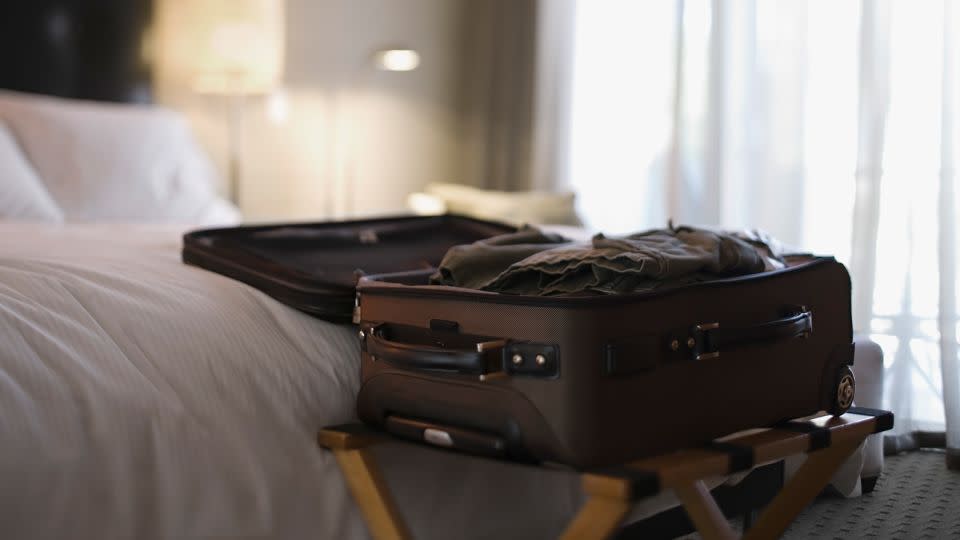 In a hotel room, place your luggage on a rack, as you see above. However, move it farther away from the bed. This suitcase is too close to the bed. If there are bugs in the mattress, they could get to the luggage. - Jupiterimages/Stockbyte/Getty Images