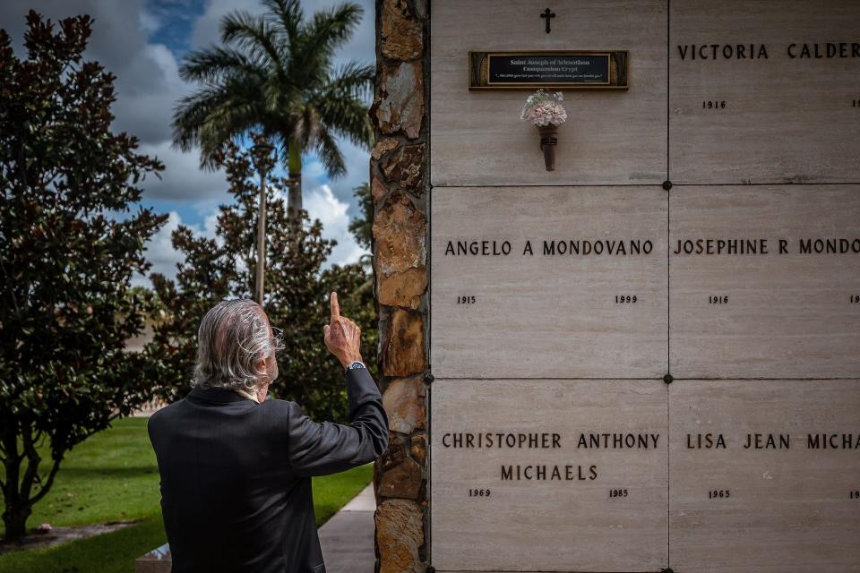 Rev. Gabriel Ghanoum point to a crypt that is part of his Nobody Buried Along project at Our Lady Queen of Peace Cemetery in Royal Palm Beach, Fla., on Tuesday, July 12, 2022.