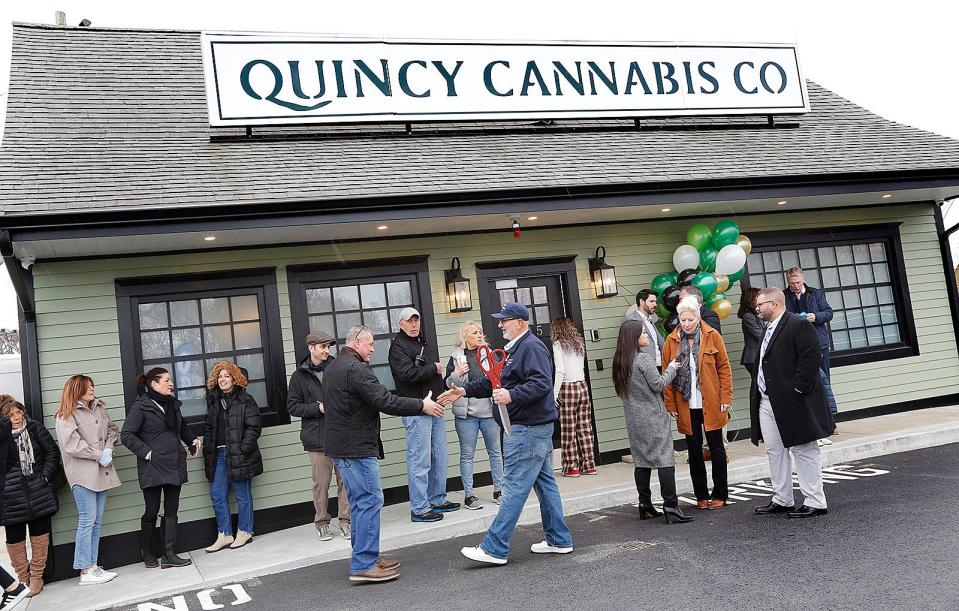 Ron Affsa, center, celebrates the opening of Quincy Cannabis at the Fore River rotary with friends and family Monday, March 13, 2023.