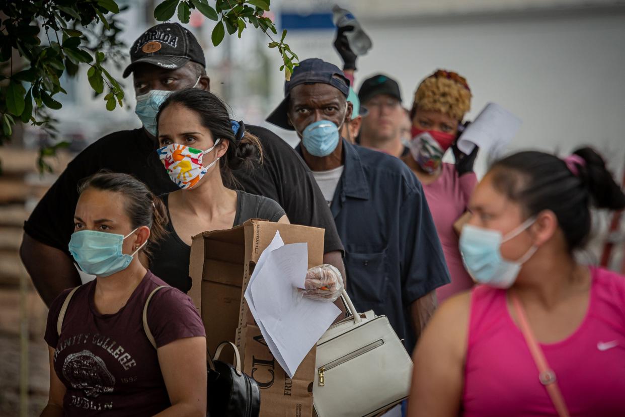 People waited in line on foot while hundreds of cars queued through the streets near the Southern Boulevard overpass at Georgia Avenue in West Palm Beach as the Hospitality Helping Hands Grocery Pick-up handed out foodstuffs in 2020.