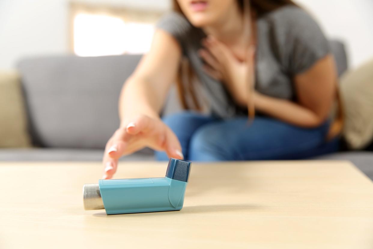 Woman reaching for her inhaler on a table