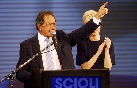 Daniel Scioli, Buenos Aires' province governor and presidential candidate, gestures as he speaks next to his wife Karina Rabolini in Buenos Aires, early August 10, 2015. REUTERS/Martin Acosta