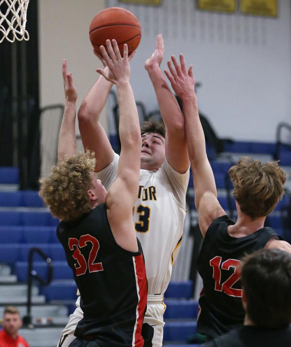 Victor's Nicholas Leonard scores on a short jumper over Hilton's Benjamin Sneddon and Jack Smith.