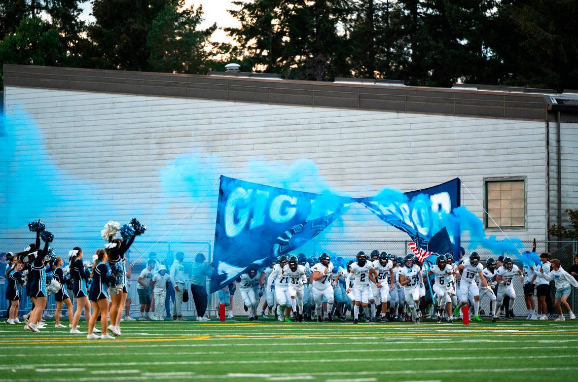 Gig Harbor’s varsity football team runs through a banner and onto the field before the start of a game against Timberline at the Roy Anderson Field in Purdy, Wash. on Sept. 29, 2022. Gig Harbor lost to Timberline 34-36 in overtime.