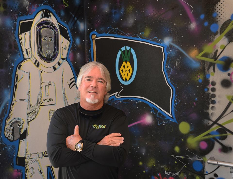 Steve Young, who owns Pineapples in Eau Gallie, stands next to an astronaut-themed mural of himself outside the venue's second-floor Moon Room.