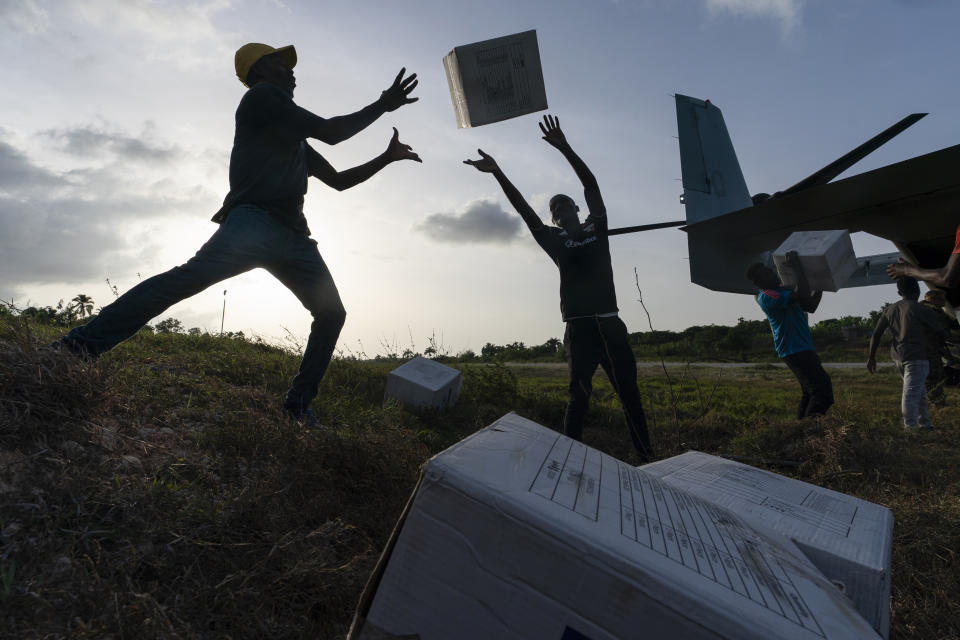 Haitian aid workers unload food from a VM-22 Osprey at Jeremie Airport, Saturday, Aug. 28, 2021, in Jeremie, Haiti. The VMM-266, "Fighting Griffins," from Marine Corps Air Station New River, from Jacksonville, N.C., are flying in support of Joint Task Force Haiti after a 7.2 magnitude earthquake on Aug. 22, caused heavy damage to the country. (AP Photo/Alex Brandon)