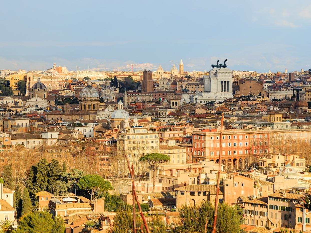 View of buildings in Rome cast in sunlight and a light blue sky