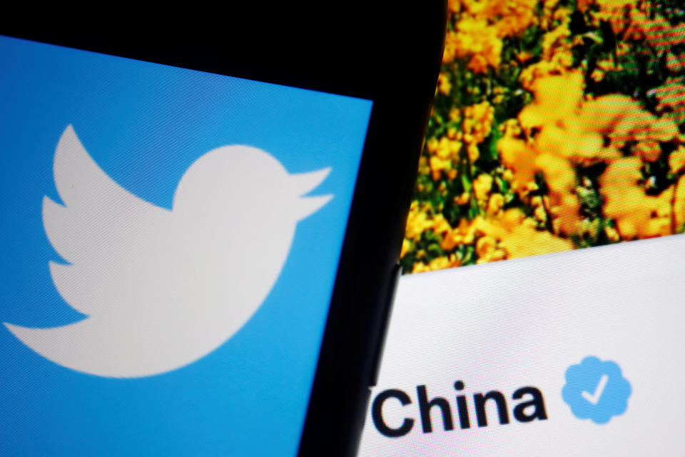 A Twitter logo is displayed on a mobile phone in front of a verified account operated by People's Daily, a Chinese state media, in this illustration picture taken September 8, 2022. REUTERS/Florence Lo/Illustration