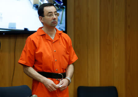 FILE PHOTO: Larry Nassar, a former team USA Gymnastics doctor who pleaded guilty in November 2017 to sexual assault charges, stands in court during his sentencing hearing in the Eaton County Court in Charlotte, Michigan, U.S., February 5, 2018. REUTERS/Rebecca Cook