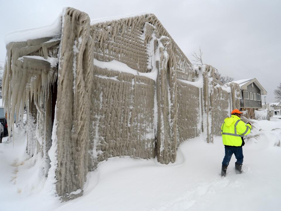 Jack Stanton checks his ice covered home after being battered with waves from Lake Erie along Hoover Beach on December 27, 2022 in Hamburg, New York.