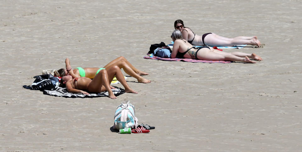 Beachgoers sunbath at Glenelg beach during a hot day in Adelaide. Source: AAP