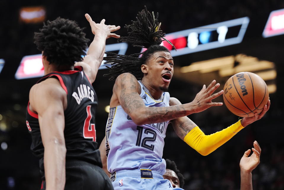 Memphis Grizzlies guard Ja Morant (12) drives to the basket past Toronto Raptors forward Scottie Barnes (4) during the first half of an NBA basketball game Thursday, Dec. 29, 2022, in Toronto. (Frank Gunn/The Canadian Press via AP)