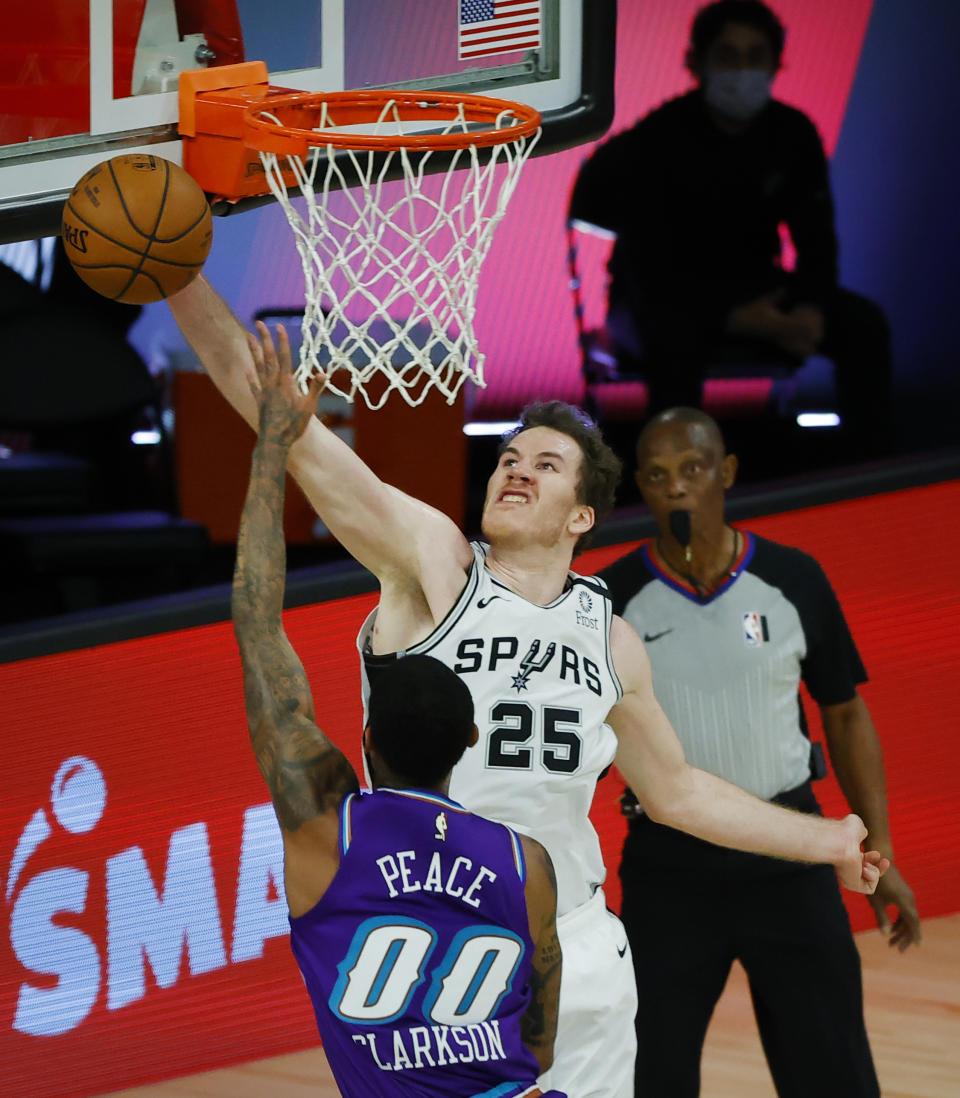 San Antonio Spurs' Jakob Poeltl (25) blocks a shot from Utah Jazz's Jordan Clarkson during the first half of an NBA basketball game Friday, Aug. 7, 2020, in Lake Buena Vista, Fla. (Kevin C. Cox/Pool Photo via AP)